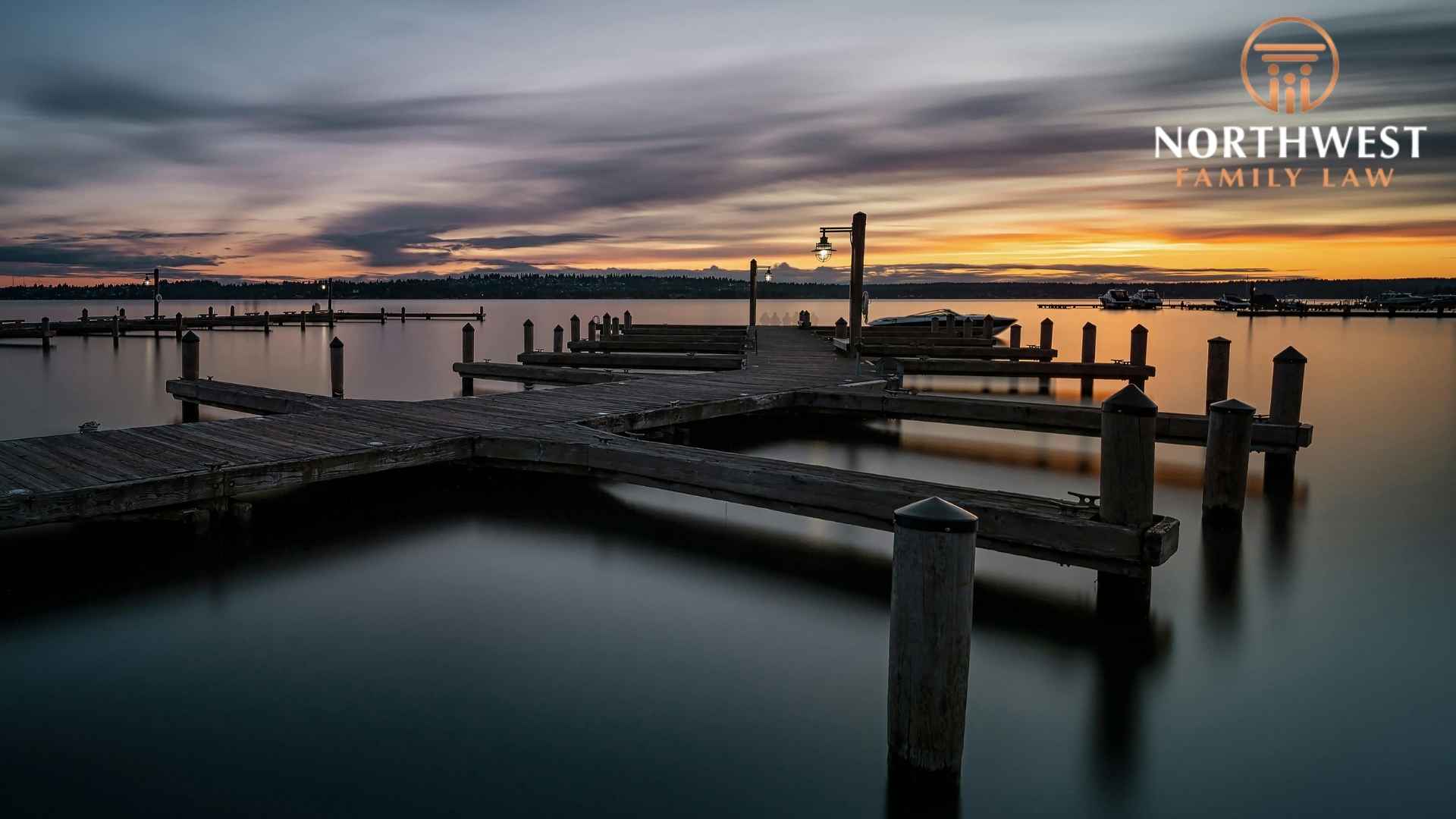 Sunset over calm lake with wooden docks.